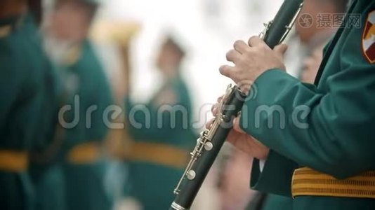 风仪阅兵式——一名身穿绿色服装的男子在节日里吹单簧管视频