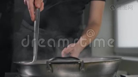 厨师用热锅炒菜，慢动作，煮亚洲面条，在热锅里搅拌视频