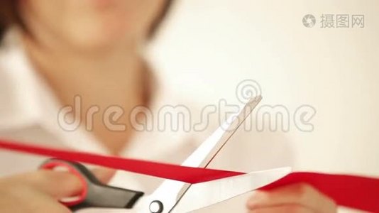 女商人用剪刀剪红丝带，然后打开活动视频