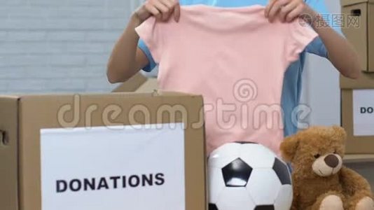 女义工在捐款箱内包装儿童物品，帮助孤儿回家视频