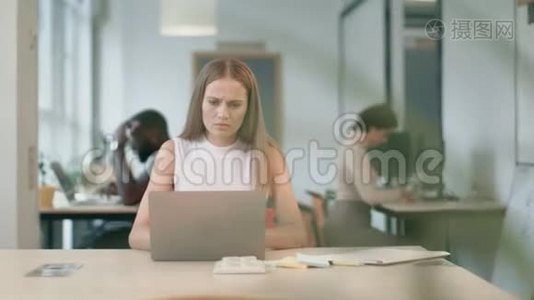 年轻女子在办公室的笔记本电脑上收到坏信。 可悲的自由职业者视频