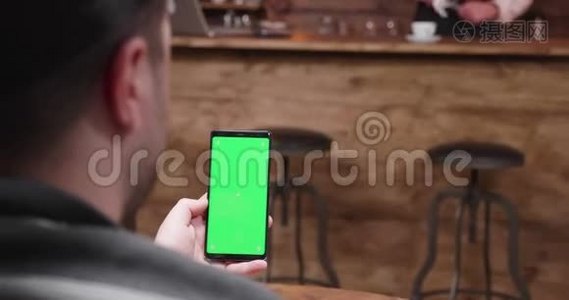 男人在手机上用绿色屏幕显示视频