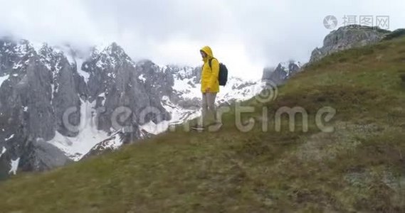 徒步旅行者在白雪皑皑的群山背景下登上一座小山视频