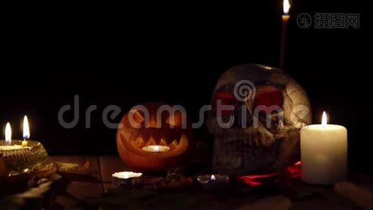 一个人的头骨和一个脸面的南瓜站在桌子上，烟雾缭绕视频