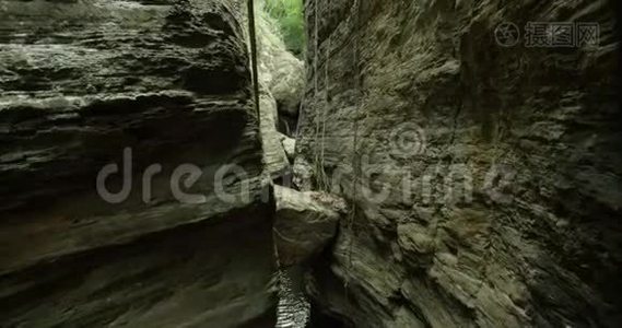 摄像机从山上和瀑布上空升起。 岩石山上的小瀑布视频