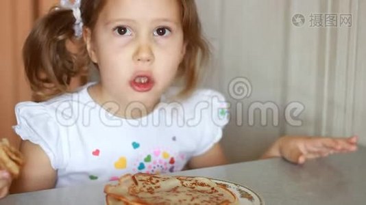 小女孩吃煎饼。 孩子吃早餐。视频