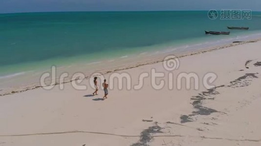 从上面看布格苏克岛上的蓬塔。 空中拍摄的旅行情侣漫步一望无际的白色沙滩，周围是绿松石视频