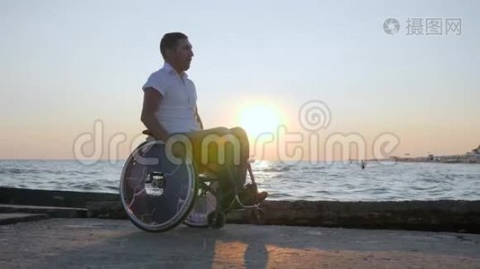 残疾人坐在河堤上的轮椅上，残疾人坐在残废的马车上，残疾男子视频