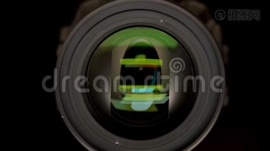 特写镜头的目标是视频摄像机与绿色反射在它孤立的黑色。视频