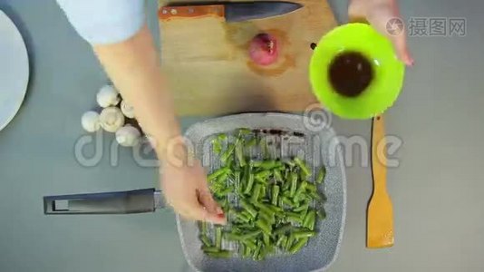 女性手将洋葱和豆子放入锅中，切香姜菇视频