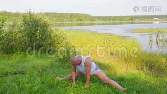 一位中年男子早上在湖边做伸展运动视频