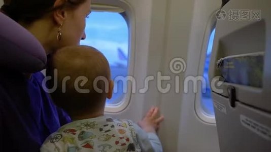 女孩和她的儿子缓慢地看着窗外的飞机视频