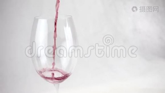 葡萄酒倒入白色背景上透明的大玻璃杯中视频
