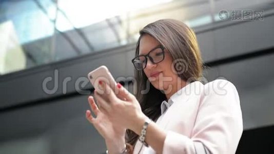快乐的年轻商务女性从智能手机获得好消息。 有很多乐趣的工人。视频