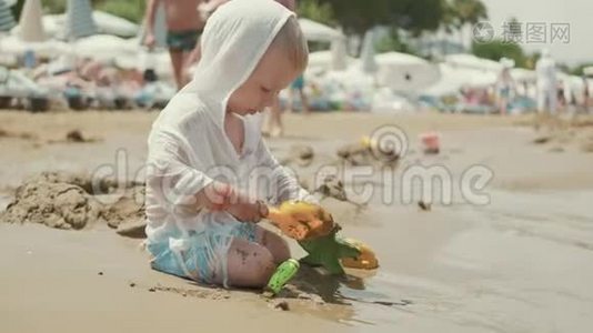 那个可爱的小男孩在海边玩沙子玩具。 孩子们在暑假在海滩度假。视频