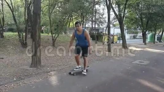 一个戴眼镜的年轻人在街上骑着一个新滑板。视频