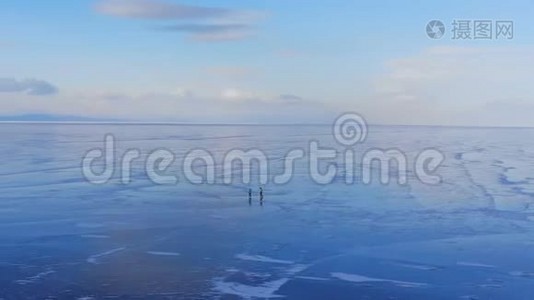 两个人在一个大冰湖上滑冰的鸟瞰图。视频