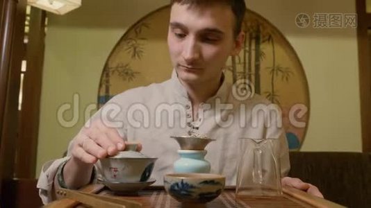茶师在仪式上用热水从水壶倒至彩湾冲泡茶视频