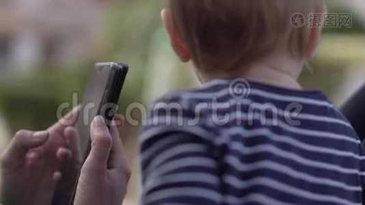 一岁的孩子看着手中智能手机的屏幕视频