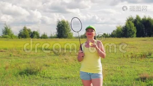 一个在空地上打羽毛球的女人发球和击球。视频