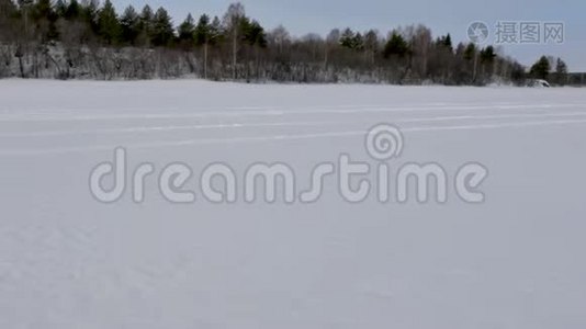 雪上摩托沿着被铁轨划过的广阔雪谷行驶视频