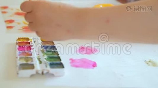孩子们`艺术家的手拿起画笔上的颜料。视频