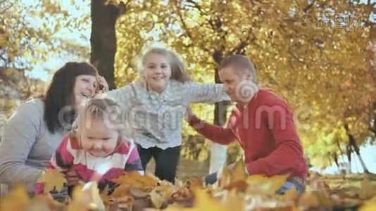 一个幸福的家庭正在阳光明媚的秋天拥抱。视频