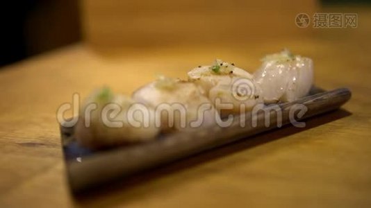 4K，吃日本木碟上的扇贝生鱼片或热生鱼片视频