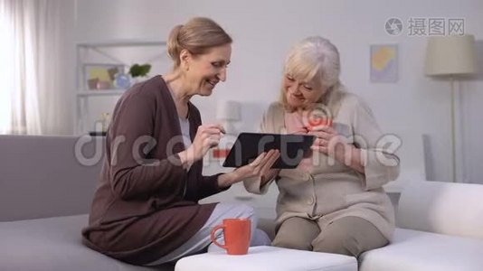 快乐的成熟女性在平板电脑上滚动网页，微笑购物应用程序视频