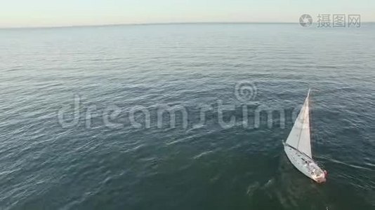 一艘帆船在海岸线附近的海上航行时被击中的空中射击。视频