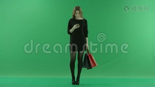 美丽的年轻女性在等待某人时购物后使用智能手机，颜色键绿色背景视频