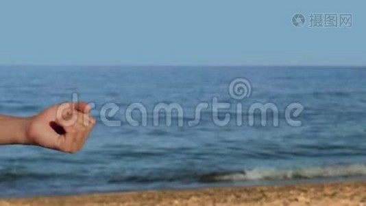 男性手在海滩上拿着一个概念全息图与文本现在租用视频