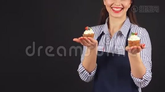 年轻女子手里拿着纸杯蛋糕的糕点师，微笑着对着镜头视频