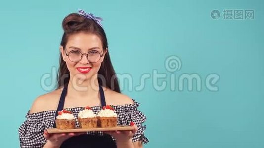 年轻女子手里拿着纸杯蛋糕的糕点师，微笑着对着镜头视频