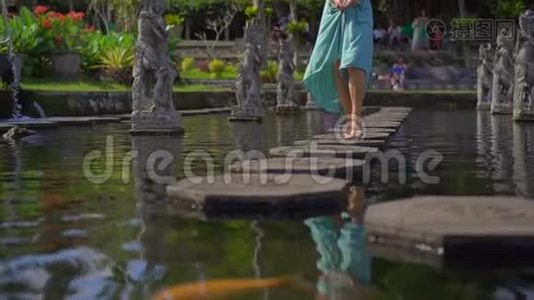 一位年轻的女游客参观巴厘岛前皇家宫殿提塔甘加水宫时的慢镜头视频