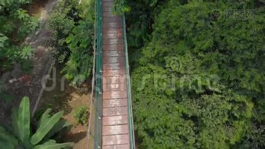 一个小男孩在丛林上空的吊桥上奔跑的空中射击。 东南亚概念旅行视频