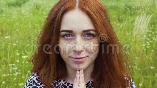 在户外祈祷红头发的女人，满脸雀斑的女人念上帝的祈祷视频