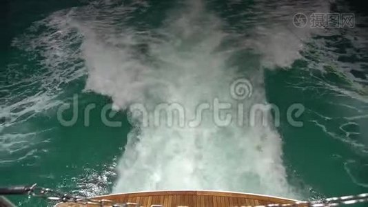完美游艇绿松石水域甲板背面明亮的近景，在螺旋流中变成白色视频