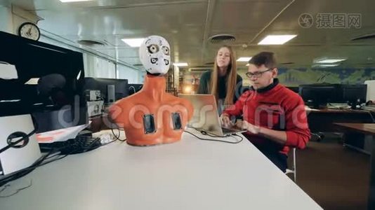 年轻的工程师正在操纵一个半机器人移动它的面部器官视频