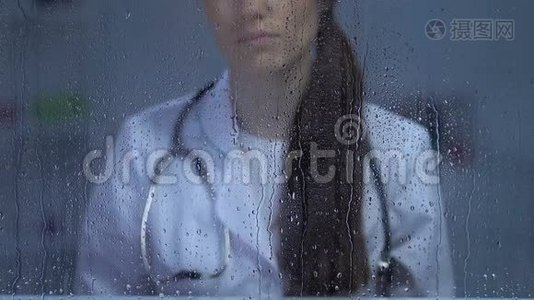 病人死亡、抑郁后不高兴的女医生在雨窗里看着视频