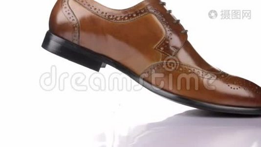 旋转一个时尚的经典棕色鞋带的白色背景。视频