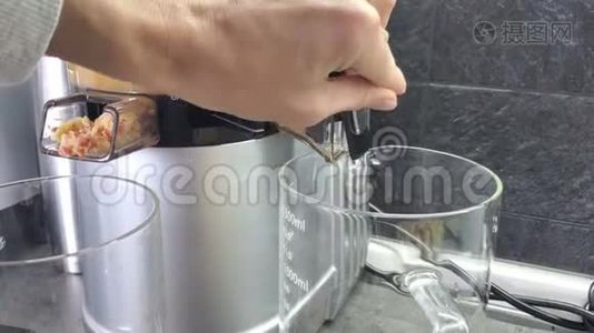 女人`手用苹果汁换水壶。 果汁从榨汁机里倒出来。 4k视频视频