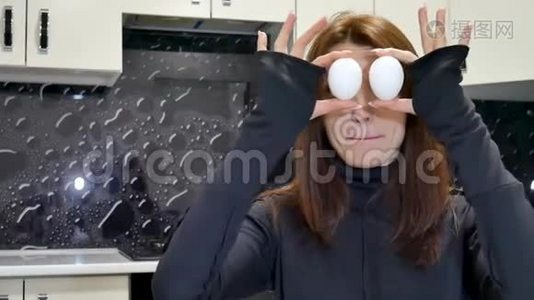 合上黑衬衫年轻女子的视频，用两个鸡蛋遮住眼睛。视频