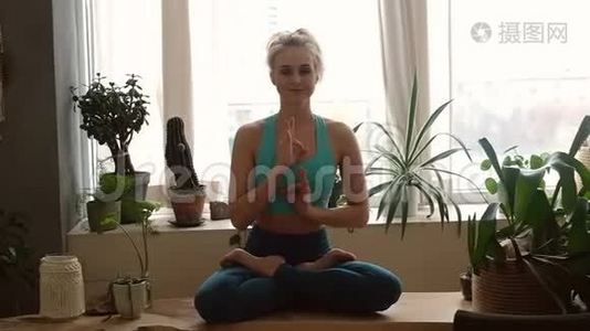 年轻漂亮的女人在家里练习瑜伽。 室内客房视频