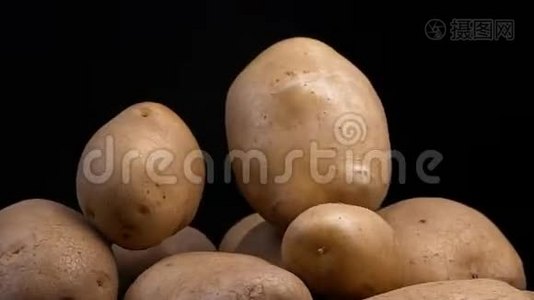 生土豆落在黑色背景上视频