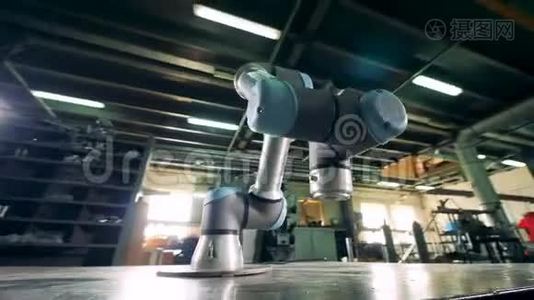 在工厂里，工作臂在金属齿轮上移动。视频