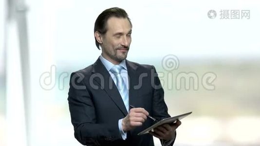 有魅力的商人在他的平板电脑上做笔记。视频
