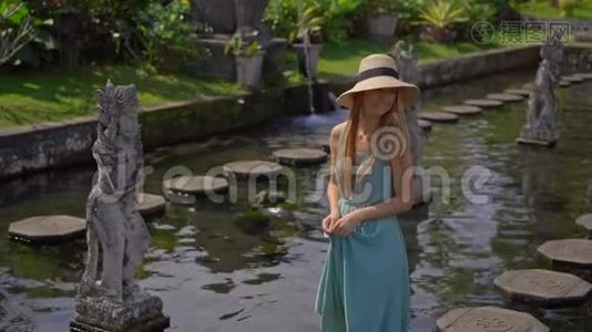 一位年轻的女游客参观巴厘岛前皇家宫殿提塔甘加水宫时的慢镜头视频