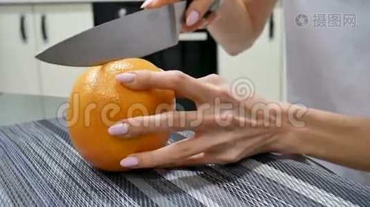 侧视女性手切新鲜葡萄柚用刀。 女性做水果沙拉。 素食观念视频