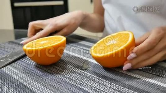 在家里的厨房里，女性的双手露出两半成熟多汁的橘子视频